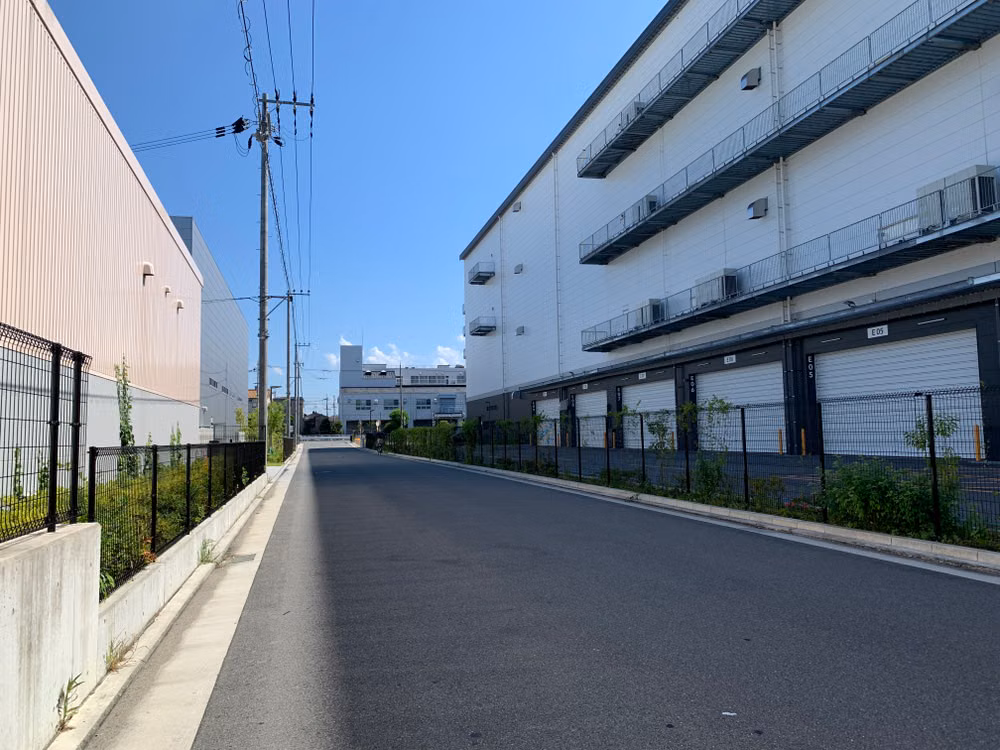 Representative image: Street view of contemporary warehouse buildings with a clear blue sky, perfect for business themes